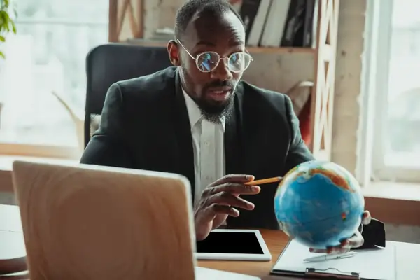 businessman pointing at globe